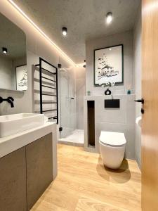 a bathroom with a white toilet and a sink at Stylish Urban Retreat In West London in Brentford