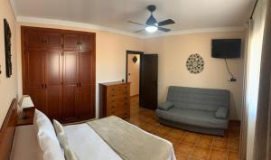 a bedroom with a bed and a couch at Casa de María in Valle de Abdalagís