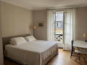 a bedroom with a bed and a large window at 100m2 flat appartement d'artiste in Paris