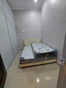 een kleine slaapkamer met een bed in een kamer bij MT HOMESTAY in Alor Setar