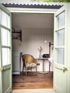 eine offene Tür zu einem Zimmer mit einem Stuhl und einem Tisch in der Unterkunft The Applehay in Constantine