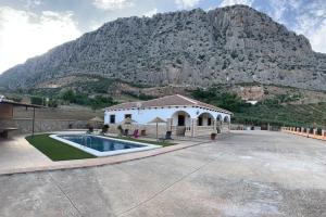 a house with a swimming pool in front of a mountain at Casa de María in Valle de Abdalagís