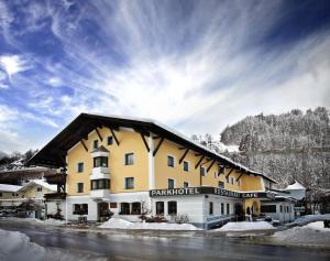 a large yellow and white building with snow on the ground at Parkhotel Matrei in Matrei am Brenner