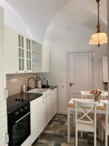 a kitchen with white cabinets and a table with chairs at Historical Center Residence 1 in Sibiu