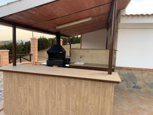 an outdoor kitchen with a fireplace and a grill at Casa de María in Valle de Abdalagís +27 photos