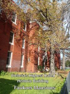 um edifício de tijolos vermelhos com uma árvore em frente em Fawkner Mansions Heritage Hotel em Melbourne