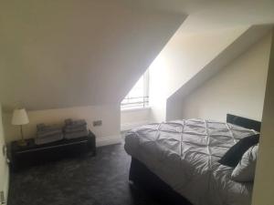 Kirkcudbright Holiday Apartments - Apartment G في كيركودبرايت: غرفة نوم بسرير كبير ونافذة