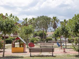 un parc avec des bancs et une structure de jeu dans l'établissement Vacancéole - Les demeures de la Massane - Argelès-sur-Mer, à Argelès-sur-Mer