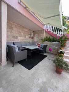 un patio con mesa y sillas en un edificio en Lilac Apartments en Trogir