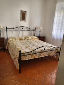 um quarto com uma cama com um edredão floral em Marina's house em Imperia