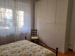 a bedroom with a bed and a cabinet and a chair at Marina's house in Imperia