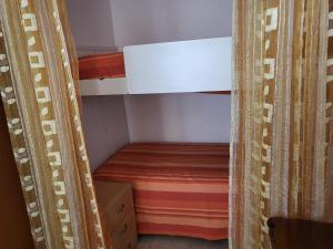 um pequeno quarto com um beliche e uma cortina em Marina's house em Imperia