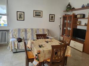 uma sala de estar com uma mesa e um sofá em Marina's house em Imperia