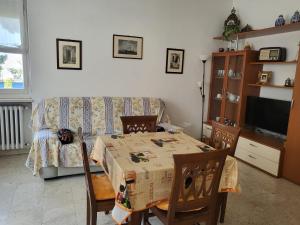 a living room with a table and a couch at Marina's house in Imperia +4 photos