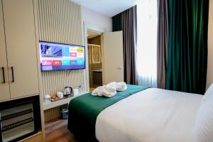 una camera d'albergo con un letto e una TV a schermo piatto di THE NEST HOTEL a Istanbul Altre 64 foto