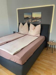 ein Bett mit weißen Kissen darüber in der Unterkunft Ferienwohnung Susan-Nur 10 Fahrminuten von Playmobil in Zirndorf