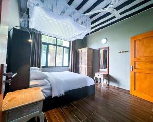 ein Schlafzimmer mit einem großen Bett und einem Fenster in der Unterkunft Aquamarina Hotel & Villas in Jambiani