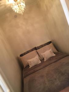 Schlafzimmer mit einem Bett mit Kronleuchter in der Unterkunft Appartement Belle Feuille in Boulogne-Billancourt