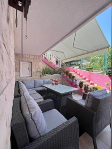 eine Terrasse mit Sofas, einem Tisch und Stühlen in der Unterkunft Lilac Apartments in Trogir