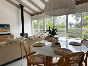 洛恩Seaview Treehouse - three minute walk to the beach的带桌子和沙发的客厅
