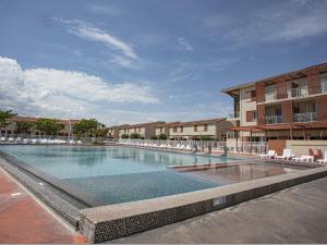 une grande piscine avec des chaises et un bâtiment dans l'établissement Vacancéole - Les demeures de la Massane - Argelès-sur-Mer, à Argelès-sur-Mer