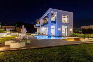 a villa with a swimming pool at night at Armonia Luxury Villa in Triánta