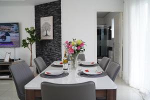 une salle à manger avec une table et des chaises blanches dans l'établissement Villa Fontenailles, à Mâcon