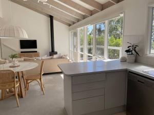 a kitchen and living room with a table and a couch at Seaview Treehouse - three minute walk to the beach in Lorne