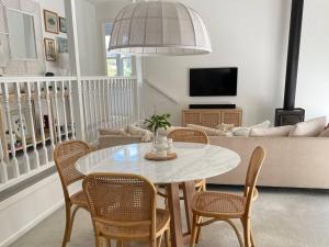 a living room with a white table and chairs at Seaview Treehouse - three minute walk to the beach in Lorne
