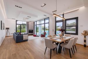 a dining room and living room with a table and chairs at Armonia Luxury Villa in Triánta