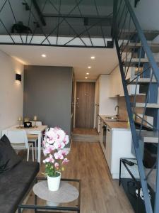 a living room and kitchen with a spiral staircase at Lofto tipo 2 kambarių butas in Kaunas