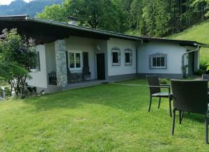 una pequeña casa blanca con un patio de césped en Ferienhaus Tauernblick, en Sankt Veit im Pongau
