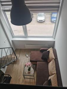 a living room with a couch and a large window at Lofto tipo 2 kambarių butas in Kaunas