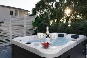 a hot tub with a bottle of wine and glasses at Pachis Escape Suites in Pachis