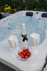 een fles champagne en een kom aardbeien in een bad bij Pachis Escape Suites in Pachis