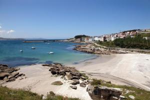 Blick auf einen Strand mit Booten im Wasser in der Unterkunft camiño dos faros in Ponteceso