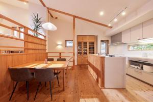 a kitchen and dining room with a wooden table and chairs at Crystal Besso Shirahama in Shirahama