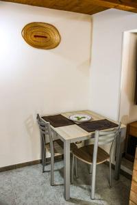 uma mesa e cadeiras num quarto com uma parede em Casa vacanze ‘A Catina’ em Modica