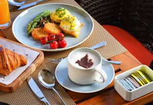 JW Marriott Hotel Bengaluru Prestige Golfshire Resort & Spa في بانغالور: طاولة مع طبقين من الطعام وكوب من القهوة