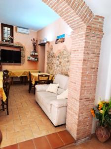 een woonkamer met een witte bank en een bakstenen muur bij Bed And Breakfast Camere Primavera in Fondi