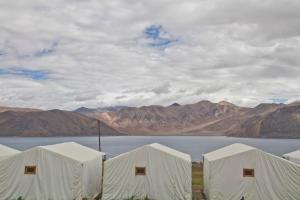 un gruppo di tende bianche di fronte a un lago di Pangong Retreat Camp a Spangmik