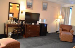 a hotel room with a desk and a television and a room at Economy Inn Bluefield in Bluefield