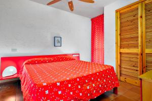 1 dormitorio con cama roja y edredón rojo en Casa Vacanza Tramontana 2414, en Cugnana