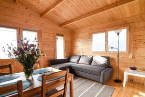 a living room with a couch and a table at słoneczny domek II in Kołczewo