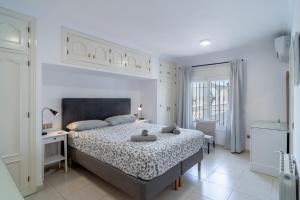 Un dormitorio blanco con una cama grande y una ventana en Ballyraine, en Nerja