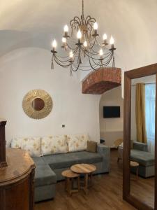 un soggiorno con un divano e un lampadario di Historical Center Residence - Old Town Sibiu a Sibiu
