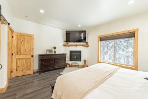a bedroom with a bed and a fireplace and a window at Bears Den in Brian Head