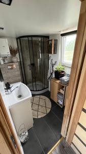 a small bathroom with a shower and a sink at Brzozowisko Zalewo in Miłomłyn