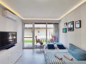 a living room with a bed and a flat screen tv at Petit Paul Apartman in Keszthely