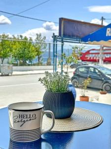 uma chávena de café e uma planta em vasos sobre uma mesa em Oasis Luxury Apartments em Erétria